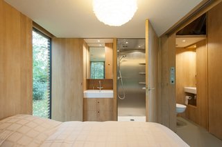 In the bedroom, a door opens directly to the stainless steel shower. A half-bath sits just outside the bedroom, allowing guests easy access to it when the wood panel dividing the bedroom from the main area is drawn. The sinks are by Duravit and faucets by Grohe.