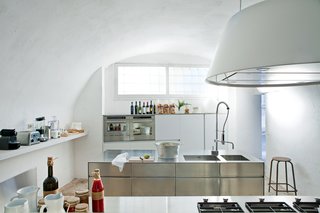 20 Best Modern Kitchen Counters - Photo 7 of 20 - The minimalist bright white modern kitchen of this Italian vacation home in Salento showcases a sleek steel cabinet system and a Kono hood from Elmar.