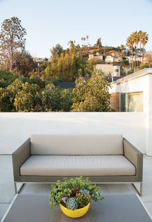 Jacobs transformed the roof into a series of decks, this deck features Crate & Barrel’s Dune sofa and coffee table.