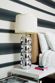 Here is a look at Graham & Brown’s Verve Stripe wallpaper that was used in a bedroom. The chrome lamp is vintage.