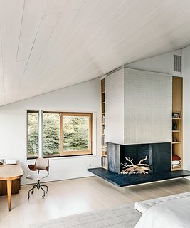 The master bedroom’s fireplace boasts a black slate hearth set in white-painted masonry.