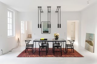This 1,500-square-foot apartment is a Moscow-based couple's second home. The stately dining setup features a custom table and Hans Wegner Wishbone chairs. PSLAB is responsible for the lighting concept throughout.