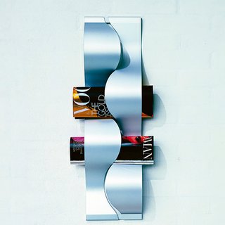 Accessorize with a purpose! Instead of simply hanging photos on your walls, use accessories that can double as storage. For instance, use a hanging magazine rack in the living room or office. The one pictured here looks more like a work of art with its flowing lines and brushed anodized aluminum material.
