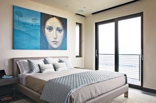 In the master bedroom, Azul Giorgione by Alberto Gálvez hangs above a locally manufactured bed from Soluzioni. The sheets, pillow cases and blanket are from Restoration Hardware; the decorative pillows and quilted coverlet are from Bed, Bath, and Beyond.