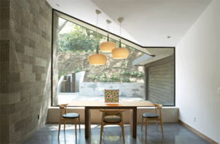 The dining area of the Kim Residence is encased in glass walls and doors, lending a sense of dining al fresco.