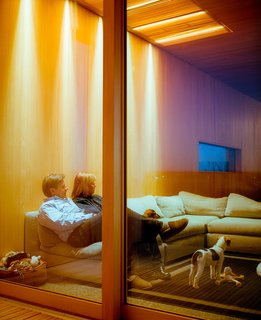 This Modern Cabin Is the Ideal HQ For a Family in Alaska - Photo 13 of 19 - The sliding doors to the deck are made by Dynamic Architectural Windows & Doors and the sofa, on which Chapoton and Buser sit is from Dellarobbia.