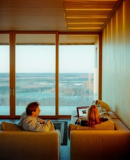This Modern Cabin Is the Ideal HQ For a Family in Alaska - Photo 19 of 19 - Inside the house, the dogs are a bit smaller. In this case, a Parson Russell terrier fits easily on the back of the sectional sofa.