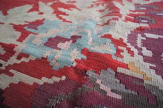 This type of kilim, with its oversized, geometric floral pattern and gapped weaving style, is typical of the Balkan region. It's a rather modern take on folk sensibilities. This rug is almost 8' x 10' and goes for $1,850.