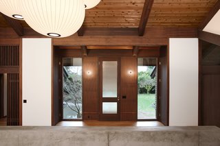 Midcentury architect Gene Zema, known for his Pacific Northwest mix of modernism and Japanese architecture, designed this house around 1974 to emphasize the texture and color of the exposed wood. Revitalized and renovated by SHED Architecture & Design, the stained-fir walls and beams contrast with the white walls, while simple paper light fixtures give it an elegant glow.