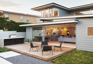 A Craftsman-Style Bungalow is Turned Inside Out - Photo 5 of 6 - A 22-foot sliding-glass door by Fleetwood opens onto an ipe deck furnished with lounge chairs, a cocktail table, and stools from Room & Board’s Penelope line. The bar is made of concrete and Richlite, a wood-fiber composite used in skateboard ramps.