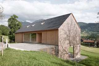 A Simple Gabled House Features an Intricate Latticework Shell - Photo 2 of 10 - Residents enter the house from the street through the upper level, which contains the bedrooms. The rafters were removed to create additional loft space.