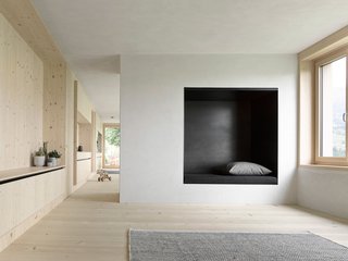 A Simple Gabled House Features an Intricate Latticework Shell - Photo 5 of 10 - Plaster walls mixed with gray marble powder dominate the interior of the bottom floor, complementing its spruce wood carpentry.