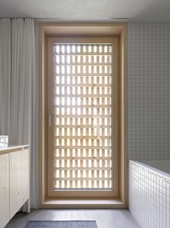 A Simple Gabled House Features an Intricate Latticework Shell - Photo 9 of 10 - The latticework shell becomes a visual motif in the bathroom, furnished with appliances from Keramag, Kludi, and Laufen.