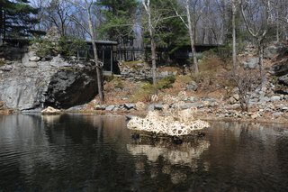 The Remarkable Home of Modernist Designer Russel Wright - Photo 2 of 9 - The house and studio were christened "Dragon Rock" by their daughter Ann who said the rock formation resembled a dragon sipping from the pool. The pool was created by feeding a waterfall into to the pit. Seen here is a floating sculpture by current artist-in-resident Stephen Talasnik.