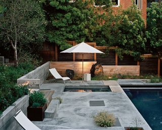 LEDs behind the slatted cedar screen cast a soft glow on the concrete and wood surrounding the lap pool.<br><br>Click here to view more photos of the renovated cottage!
