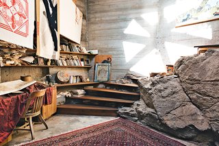 A handful of operations staff live in on-site apartments. Rather than dig out a boulder that’s part of the mesa Arcosanti rests upon, builders incorporated it into the room. Woodworker Tim Daulton constructed the staircase.<br><br>Photo by: Peter Bohler