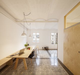 A set of birch plywood pieces, used to create sliding doors, benches, and storage, added subtle accents and maximized the space. The apartment features a very open floor plan centered around the custom dining room table.