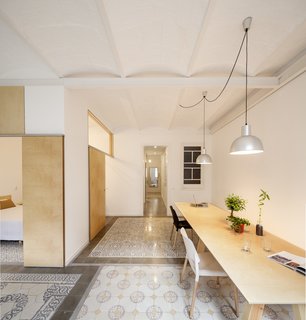 A 1930s apartment in Barcelona was renovated by Adrian Elizalde, where the architect removed interior walls and an old plaster ceiling, revealing original masonry arch ceiling construction. Covered with a coat of white paint, the ceiling provides subtle texture and pattern to the smooth and neutral white and plywood walls.