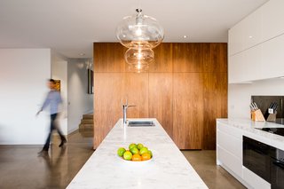 The feature lighting consists of incandescent bulbs encased in clear glass. Its brightness is complemented by spot lighting located along the room’s perimeter.