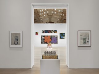 From Warhol’s famous hyper-color prints of hibiscus flowers (background), to his little known (unreleased) perfume collaboration (contained within the silver Coke bottles in front).<br><br>Credit Stefan Altenburger, Courtesy The Brant Foundation