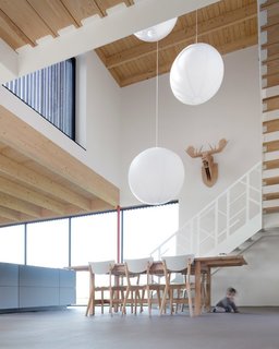 "All our kids moved out long ago, but now all the grandchildren stay over frequently," Wilma said. "The open space is great for them. They can bike and run around inside and with the walls of windows, we can keep an eye on them when they’re outside." The stairs were custom made by Level Trappen, with a steel railing resembling interlaced branches from the nearby forest.