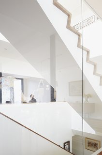 Large windows by Alumilex and an operable Velux skylight—with built-in rain sensor to automatically close it in case of unexpected showers—flood the home with light. A glass wall surrounding the staircase reflects a chalk mural by artist Tyson Bodnarchuk.