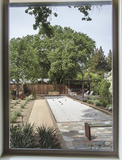 Landscape architect Josh Chandler installed a 13-by-61-foot bocce court alongside Russian sage and caper plants. A glass slab bench, embedded with LEDs, lights up at night.