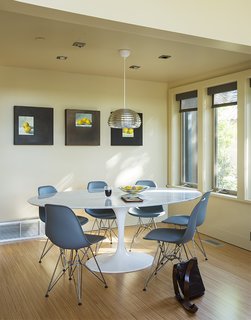 Inside the prefab residence, molded plastic Eames chairs from Design Within Reach rest beneath a Splugen Brau pendant light from Flos.