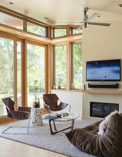 The living area opens up to a patio with views of a neighboring vineyard. Paulistano armchairs from Design Within Reach and a Ligne Roset Togo sofa surround a Dunn coffee table from Room & Board. The fireplace is from Montigo.