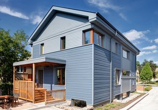 The exterior was clad with LP SmartSide in alternating bands of textured and smooth siding and basement areaways are constructed of site-salvaged brick-filled gabions.<br><br>Photo by: Eric Hausman Photography