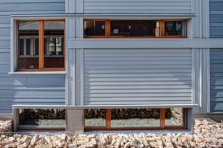 The south windows provide much of the winter-free heat as well as the opportunity to break down the wall’s mass into a dynamic composition.<br><br>Photo by: Eric Hausman Photography
