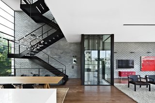 The residents use either the black steel staircase or a glassed-in elevator by Wittur to get around the house.
