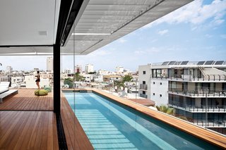 The decking on the rooftop is Burmese teak and the colorful Picot pouffes are by Paola Lenti.