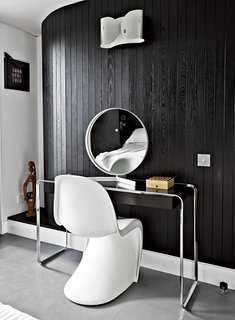 The Power of Color and What Each Shade Is Best For - Photo 2 of 11 - Near the room’s curving wall, a Verner Panton chair joins a K2 B console table by Tecta, topped by a vintage mirror by Robert Welch. The wall light is from Flos. "If I had more space, I’d just fill it with more stuff," says Pearce. The black-and-white palette echoes the home's exterior.