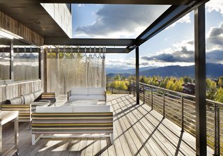 A Custom, LED-Lit Slide Twists Through This Family-Friendly Vacation Home - Photo 8 of 11 - The Conine family engineered the stainless-steel chain-mail mesh curtain system themselves using bedsheets to mock up the design. In the final version, a sunscreen with grommets from Whiting & Davis blocks the blazing sun while standing up to the strong winds of the Jackson Hole valley.