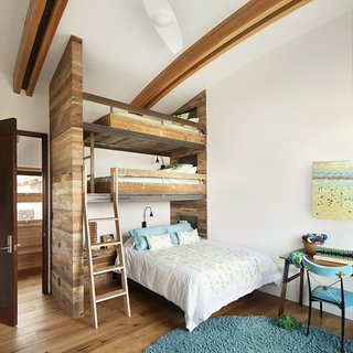 A Custom, LED-Lit Slide Twists Through This Family-Friendly Vacation Home - Photo 9 of 11 - Compact bedrooms mean more space for communal areas. The room designed for the Conine’s daughter boasts a custom three-level bunkbed for sleepovers. The wool rug is by Chandra, the bedding is by Coyuchi, the desk is by Misewell, and the chair is by Jonathan Adler.