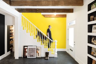 Light from a new skylight pours into the home's entryway and living room. Steel columns and beams were added for structural reinforcement, and the couple left all beams, old and new, exposed.