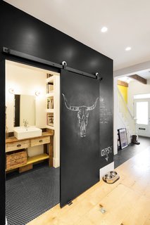 The chalkboard wall also acts as a sliding pocket door to the first floor bathroom. To maximize usable space, there are no hinged doors in the home's interior.