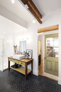 The bathroom vanities were crafted from salvaged partition wall framing and original floorboards. Sustainability is a guiding principle of Fekete and de Loera's design, and materials were repurposed and upcycled wherever possible to honor the history and character of the 135-year-old row house.