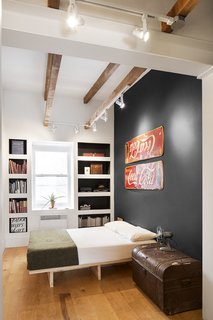 Boasting 11-foot ceilings, the master bedroom showcases and celebrates numerous antiques unearthed from the home during demolition. Midcentury enamel Coke signs, found under layers of rotting wood, became graphic accent pieces. A stately trunk, also uncovered from the renovation, is a centerpiece of the room and home, which is coincidentally located on Grand Trunk Street in the Pointe-Saint-Charles neighborhood of Montreal.