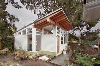 A Tiny Backyard Studio in Seattle Filled With Midcentury Finds - Photo 1 of 8 - The studio occupies the corner of a backyard filled with carefully-tended plants. They positioned the studio at the yard’s far corner, diagonal from the main house’s back door, to create a path through the garden that would engage visitors in landscape.
