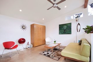 A Tiny Backyard Studio in Seattle Filled With Midcentury Finds - Photo 6 of 8 - The coffee table, red Memorex video ball TV, and red Mercer candlestick phone are all thrift store finds. The ceiling fan from Modern Fan Company is contemporary, but matches the retro aesthetic.