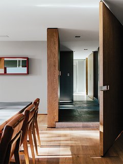 A Lush Retreat With a Sheltered Rooftop Pool in Mexico City - Photo 10 of 14 - Farca also designed the custom millwork throughout the house, such as the swinging door leading into the dining room. The leather Siren dining chairs are by Holly Hunt.