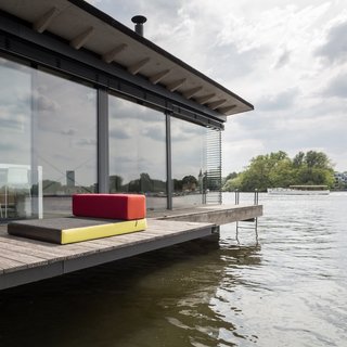6 Modern Homes on the Water - Photo 5 of 6 - In Berlin, Germany, brothers Chris and Oliver Laugsch bought a one-of-a-kind house boat for their vacation rental company, Welcome Beyond. Initially built as a home by a Dutch designer, the Modern House Boat is a three-room, 645-square-foot floating hotel. Instead of crisp sheets and room service, they offer a stellar city view and blissful peace and quiet.