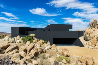 The house seems to claw onto the surrounding landscape, nestled on an outcropping with nearly 360 degree views of the surrounding desert.