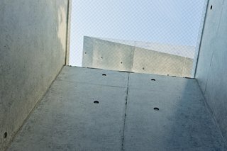 Just above the small entrance vestibule, he incorporated a skylight, which brightens the space and allows a peek at the apex of the adjacent roof’s concrete overhang.