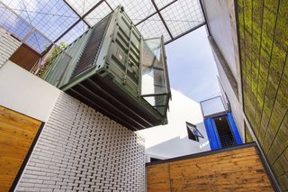 12 Shipping Container Homes That Challenge the Meaning of Shelter - Photo 3 of 12 - Atelier Riri devised creative ways to make living inside a shipping container in Indonesia’s tropical climate both comfortable and economical. The architects layered recycled pine, glass, wool, and planter mesh on top of the home.