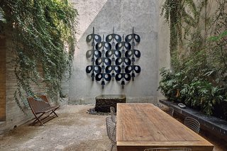 The house features several courtyards, conveying an ever-present sense of indoor-outdoor living. Concrete walls are lined with yellow jasmine, and the wall sculpture is taken from Manuel Felguérez’s fence for the National Anthropology Museum.