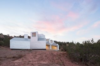A small airspace separates the building's aluminum skin from the wall underneath. The aluminum acts like a heat sink during the day: it absorbs heat but remains thermally separated (by the narrow gap) from the Element House walls.