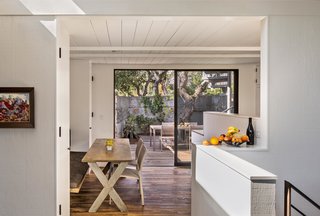 Bright Renovation of a 1970s Big Sur Home - Photo 6 of 10 - Guests now dine on a table from Coup d’Etat in the space where the residents used to enter the house. The dining room feels much larger than it actually is, thanks to a ten-foot-wide sliding glass door that opens onto a second, outdoor lounge.